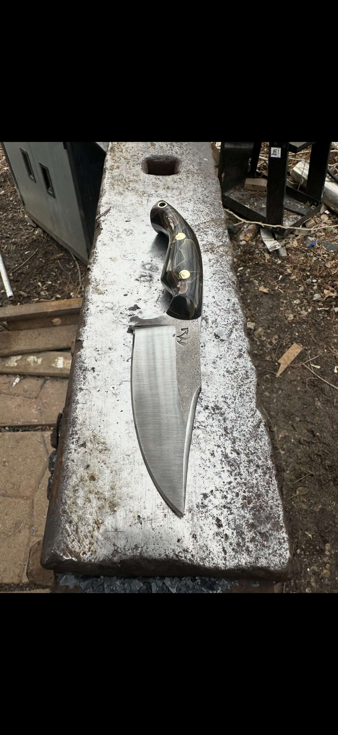 Long fighter blade with dark handle on concrete